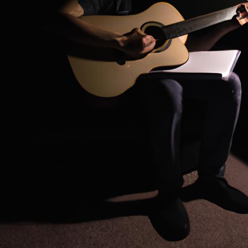 Người đang ngồi một mình trong căn phòng tối, cầm guitar và viết lời cho một bài hát cảm động.
